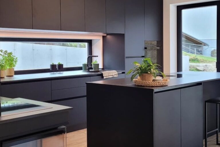 olina Küche mit schwarzen Fronten in matter Ausfhrung, Kochinsel mit schwarzem Naturstein und schwarzer Armatur
