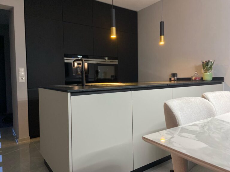 Küche mit schwarzer Front, Insel in creme beige, Arbeitspaltte in schwarzem Naturstein