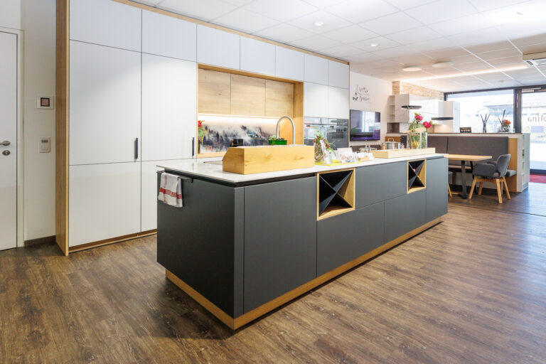 Küche mit weißer Front und Eiche natur, Insel in schwarz Matt und heller Keramikarbeitsplatte