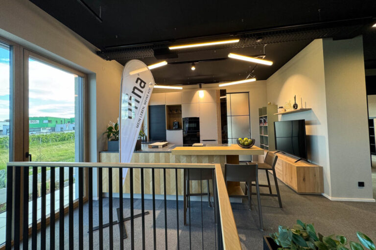 Küche mit grauer Front in matter Ausführung, Kochinsel in Eiche natur mit Fischgratoptik, Wohnzimmerverbau