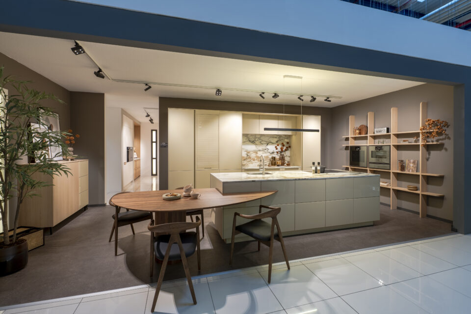 Küche in grau_grün mit integriertem Tisch auf Insel