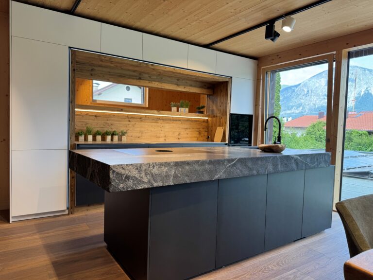 Küche mit weißen Fronten und Niesche in Naturolz mit Insel, Natursteinarbeitspaltte in Granit mit Bruchkante