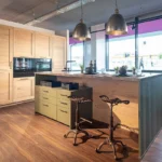 Landhasuküche in Holz natur mit Insel in grün und dunkler Arbeitsplatte