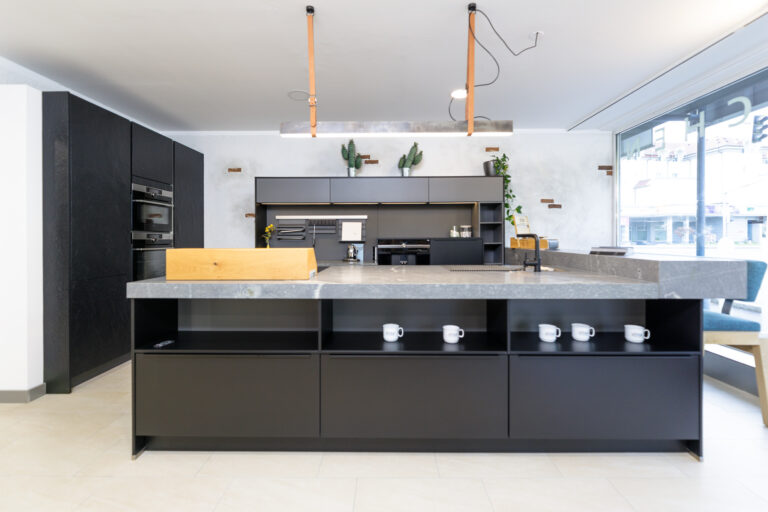 Küche in Schwarz matt mit Arbeitsplatte mit Thekenfunktion in Naturstein grau