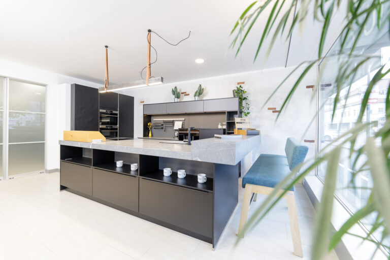 O-Küche in schwarz matt mit grauer Natursteinarbeitsplatte