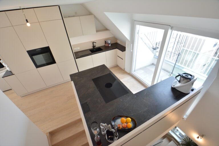 Küche in O-form, weiß matte Front, Arbeitsplatte mit schwarzem Naturstein