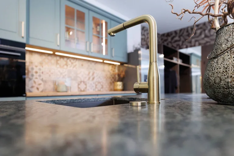 Detail - olina Landhausküche in grün mit grauer Granitarbeitsplatte und Armatur in Messing