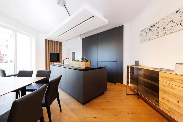 olina Küche in schwarz matt kombiniert mit Sideboard in Eiche natur, Arbeitsplatte schwarzer Naturstein