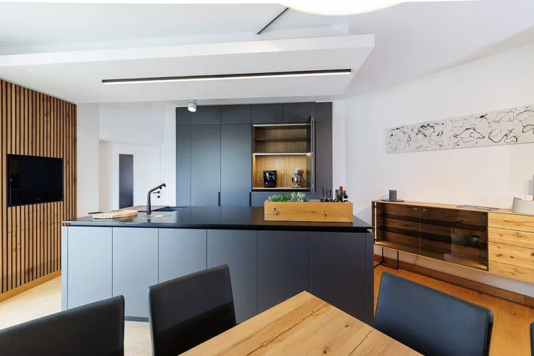 olina Küche in schwarz matt kombiniert mit Sideboard in Eiche natur, Arbeitsplatte schwarzer Naturstein