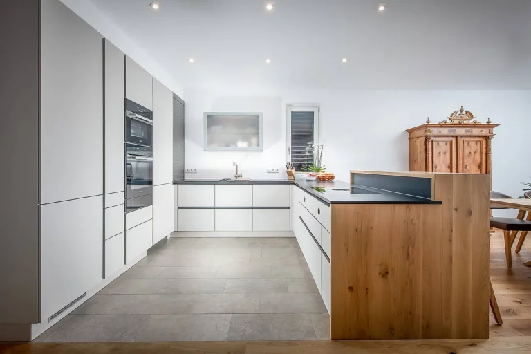 olina Küche modern mit Front in weiß matt und Baraufsatz in Eiche Natur, schwarze Arbeitsplatte in Naturstein