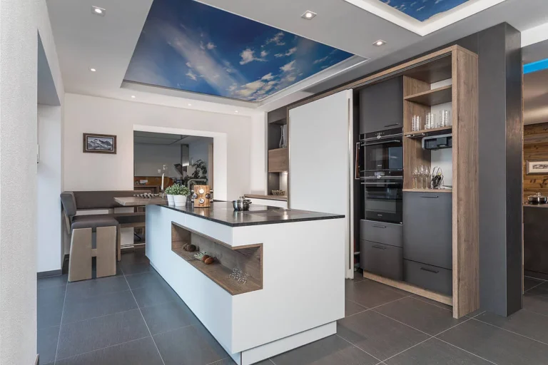 Küche mit weißer Front und Schiebetür, Insel in weiß mit Baraufsatz und Eckbank