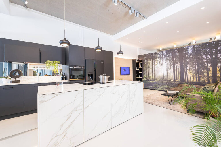 Küche mit schwarzen Hochschrankfronten in matt, Insel in weißer Keramik in Marmoroptik