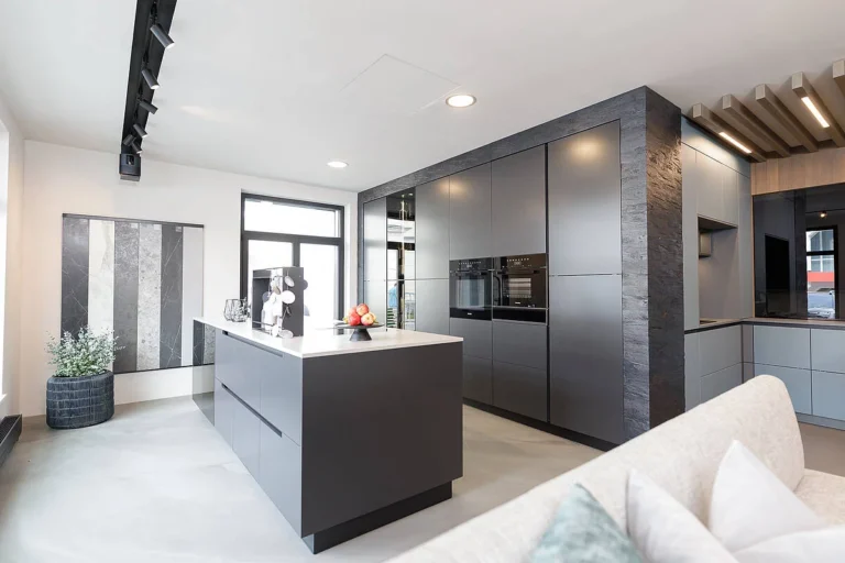 Küche mit Insel mit anthrazit matter Front u nd weißer Natursteinplatte