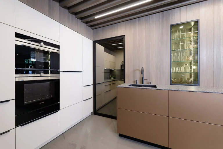 olina L-Küche mit weiß und Natruholztäfer kombiniert. Insel mit Keramikarbeitsplatte und lackierter Front in beige