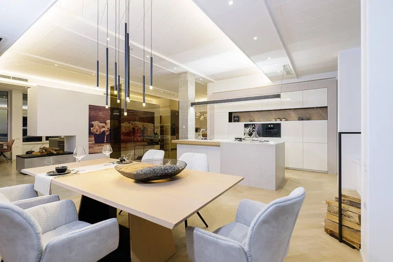 Küchen-Esszimmer Kombination mit weißer Küche in Hochglanz und Insel in Betonoptik