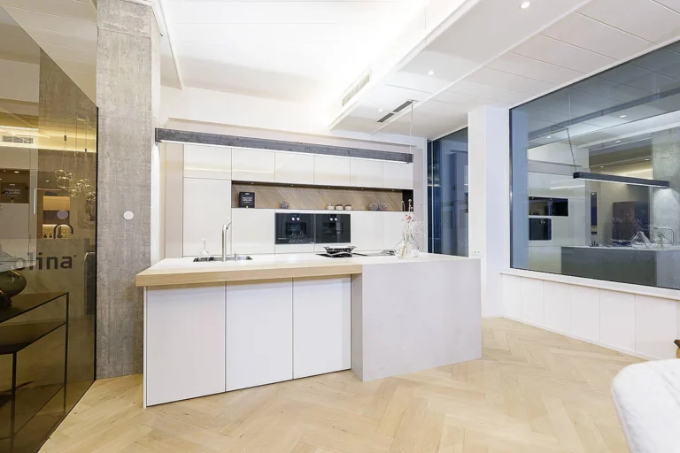 Weiße Küche in hochglanz, Insel mit Thekenansatz und Arbeitsplatte in Betonoptik